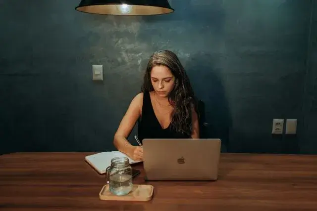 Adulta estudando online em uma mesa de trabalho.